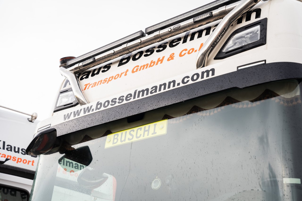 Rückseite eines weißen Lastwagens mit Firmenlogo „Klaus Bosselmann Transport GmbH & Co.!“, „www.bosselmann.com“ und Kennzeichen „BUSCHI“.